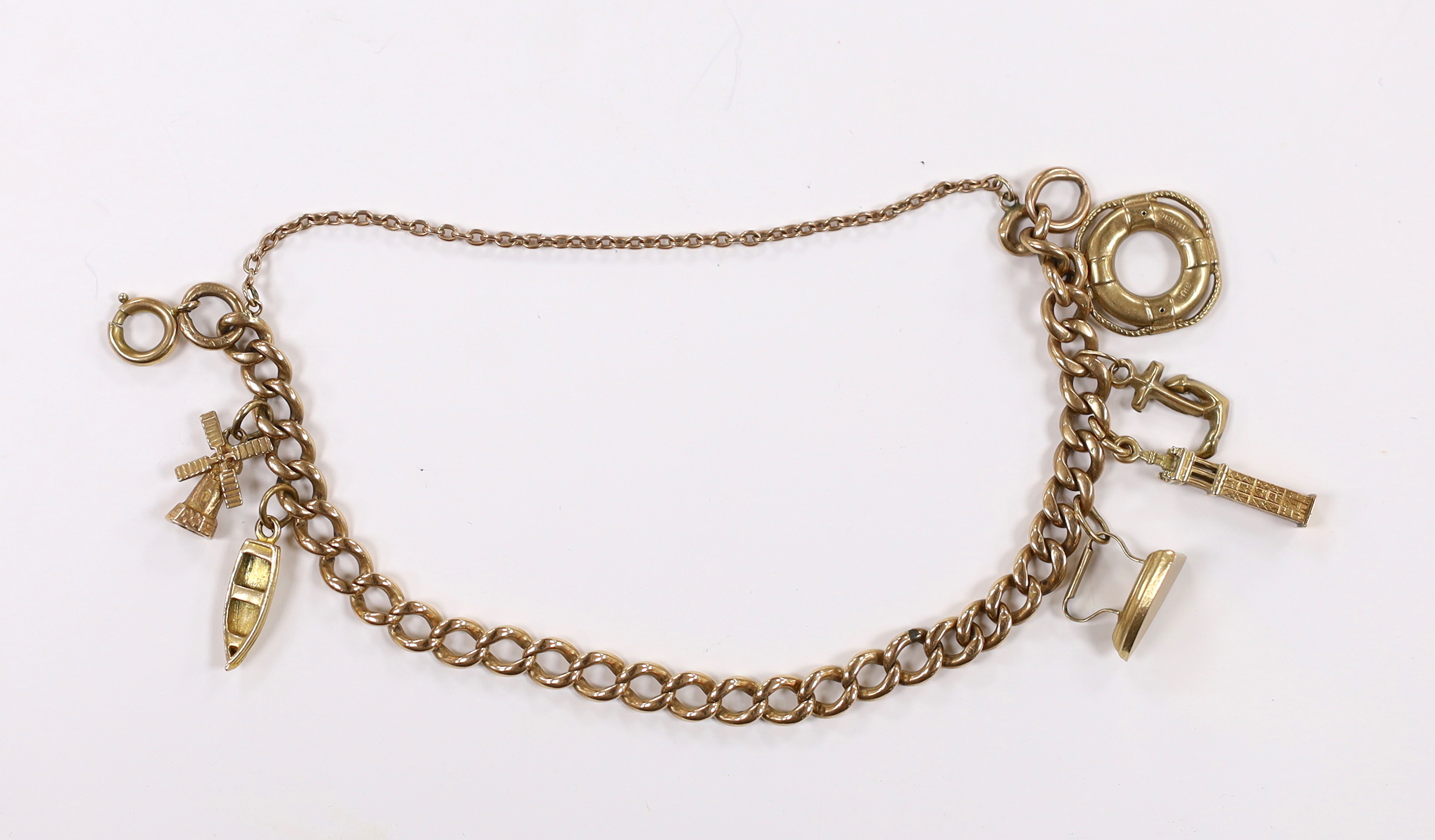 A 9ct curb link charm bracelet, hung with six assorted charms, including five 9ct gold, gross weight 19 grams.